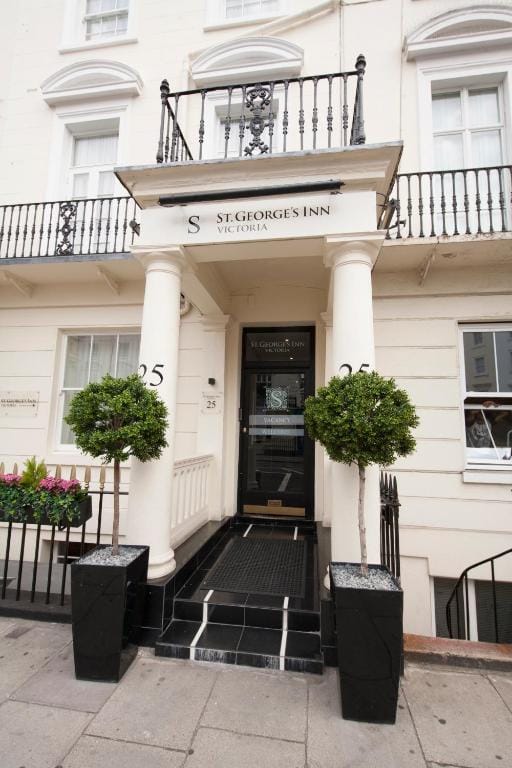 The hotel's black front door on Belgrave Road, flanked by clipped bay trees
