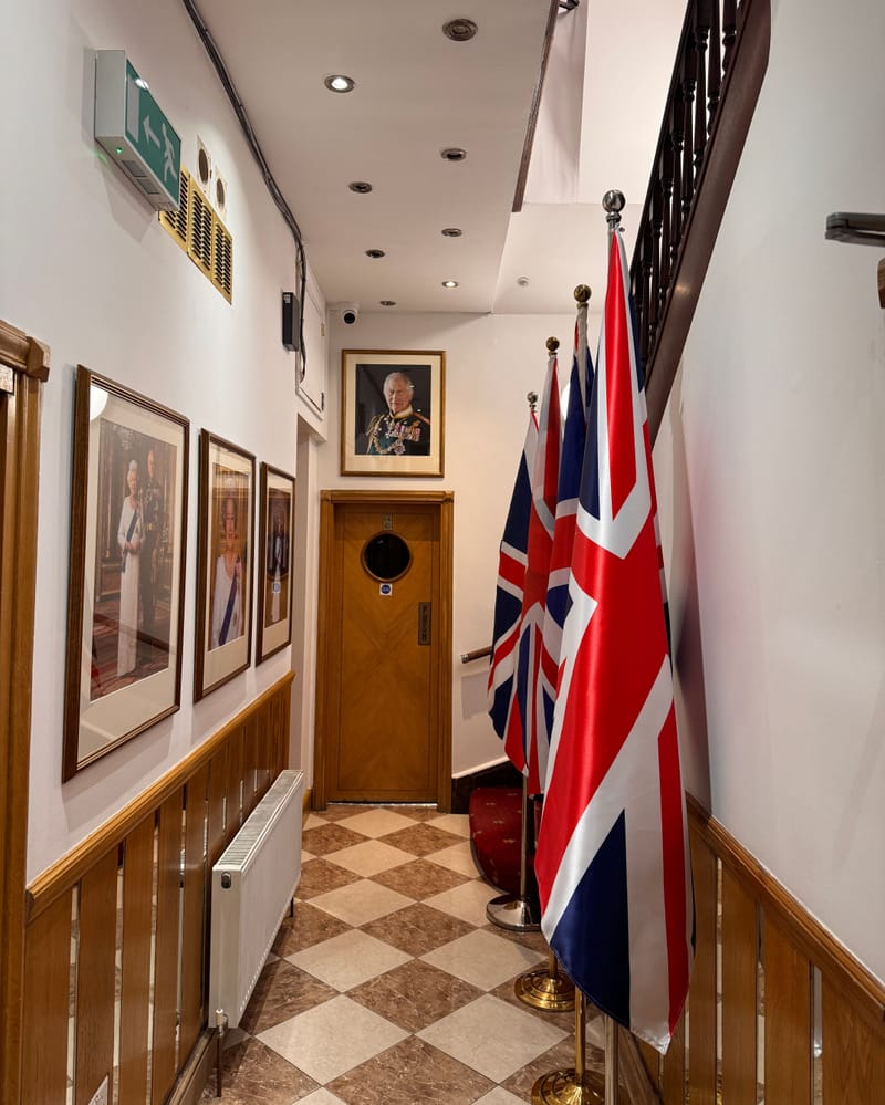 The entrance hall, with its Union flags, royal portraits and oak panelling